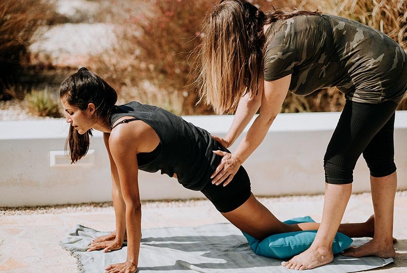 Yoga practice outdoors with assistance.